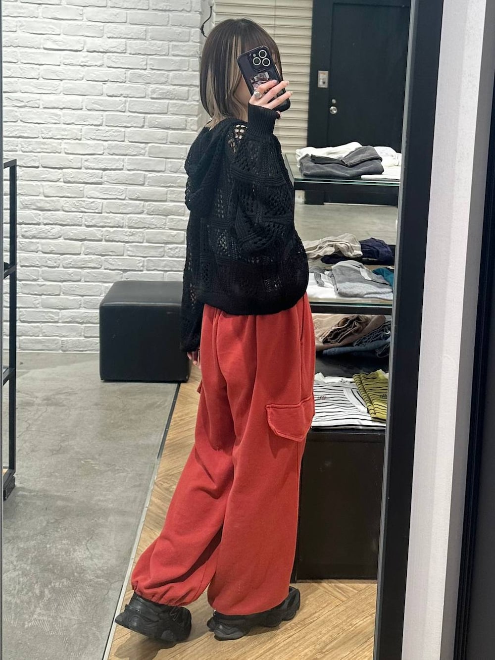 ブラック系のパーカー、グレー系のタンクトップ、レッド系のその他パンツを着用したレディースの春コーディネートの2枚目の写真