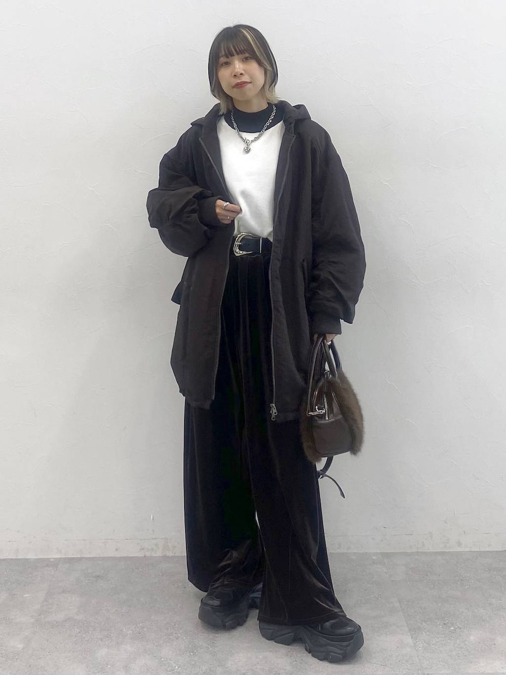 ブラック系のブーツ、ホワイト系のニット/セーター、ブラウン系のブルゾンを着用したレディースの秋コーディネートの3枚目の写真