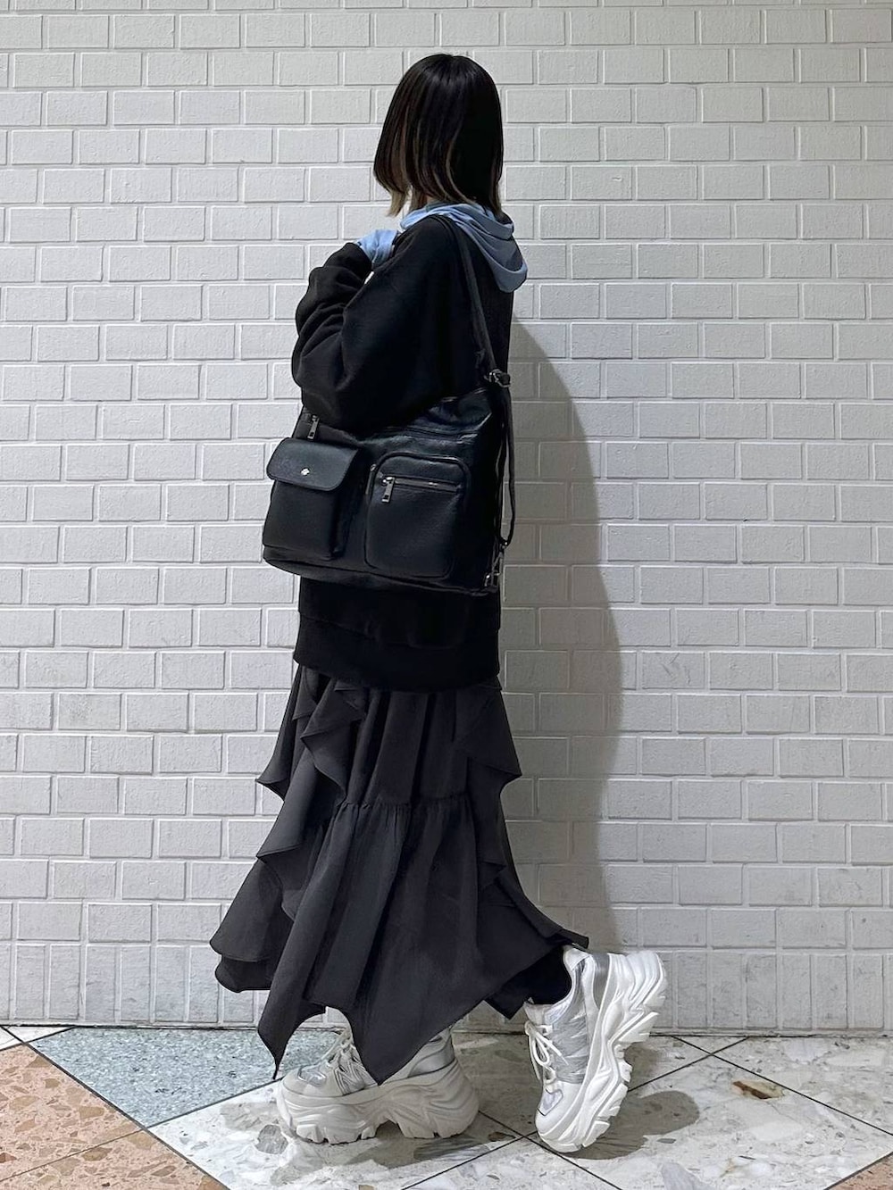 ホワイト系のスニーカー、グレー系のスカート、グレー系のスウェットを着用したレディースの冬コーディネートの5枚目の写真