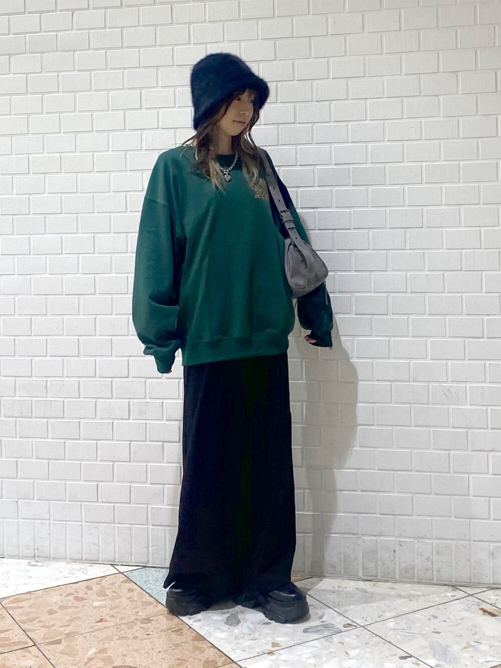 ブラック系のブーツ、ブラック系のスラックス、グレー系のショルダーバッグを着用したレディースの秋コーディネートの3枚目の写真