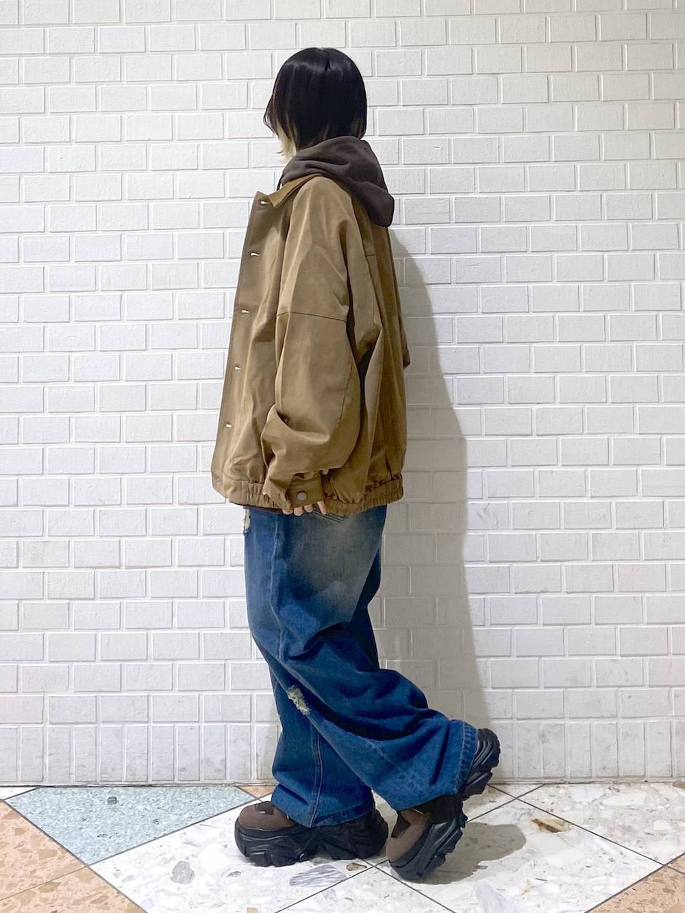 ブラウン系のブーツ、ブルー系のデニムパンツ、ブラウン系のパーカーを着用したレディースの秋コーディネートの6枚目の写真