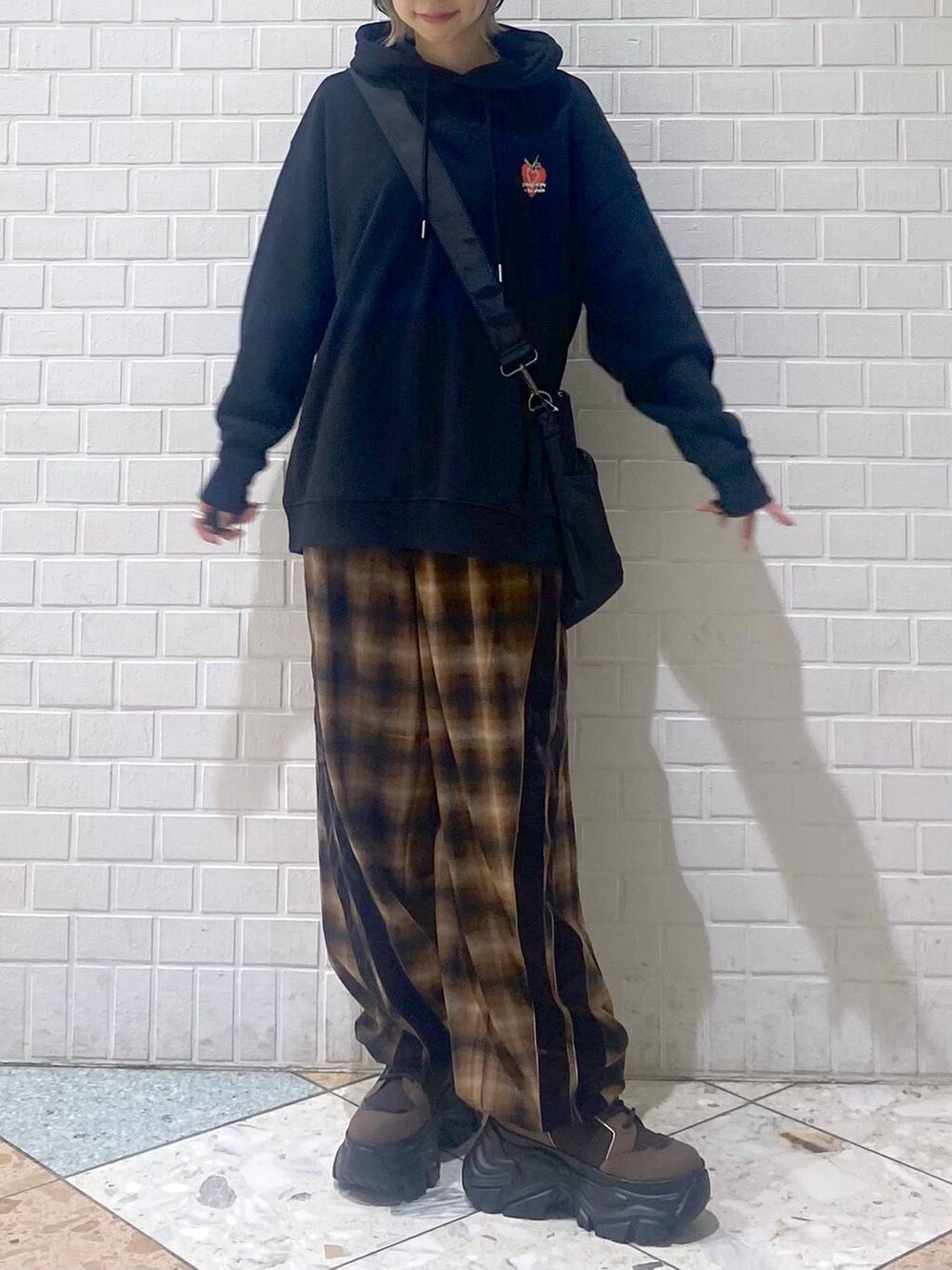 ブラウン系のブーツ、ブラック系のボストンバッグ、ブラック系のパーカーを着用したレディースの秋コーディネートの8枚目の写真