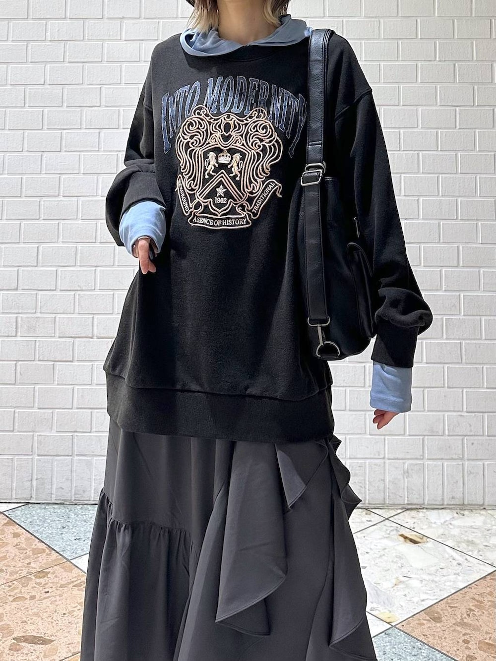 ホワイト系のスニーカー、グレー系のスカート、グレー系のスウェットを着用したレディースの冬コーディネートの8枚目の写真