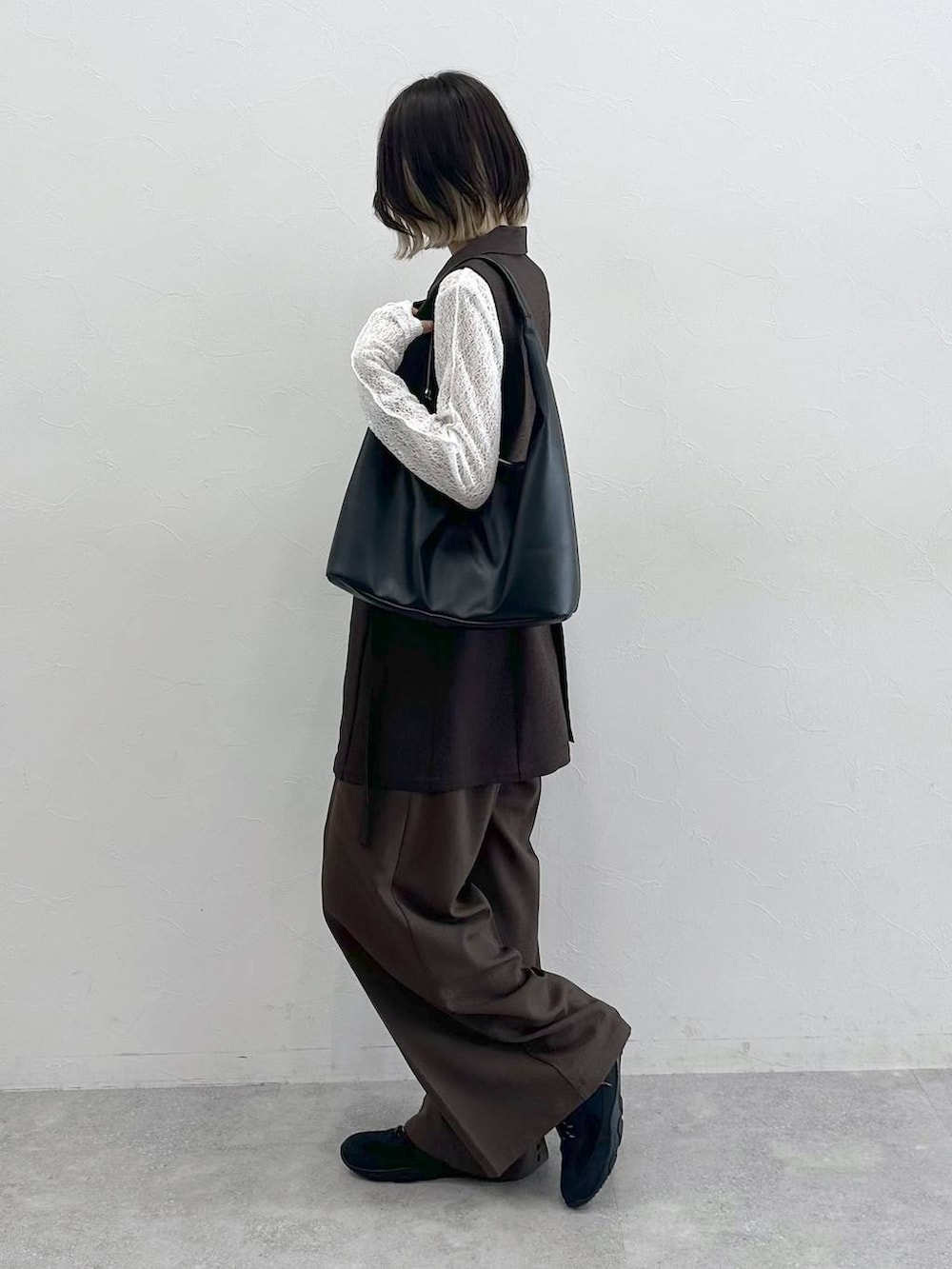 ブラック系のスニーカー、ブラック系のトートバッグ、ホワイト系のTシャツ/カットソーを着用したレディースの夏コーディネートの6枚目の写真