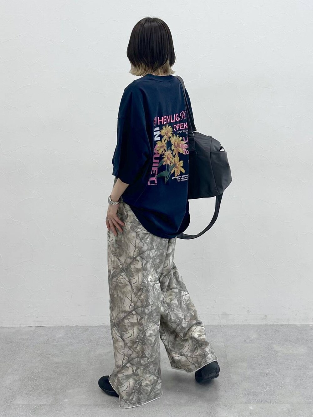 グレー系のボストンバッグ、ブラック系のスニーカー、ブルー系のTシャツ/カットソーを着用したレディースの夏コーディネートの2枚目の写真
