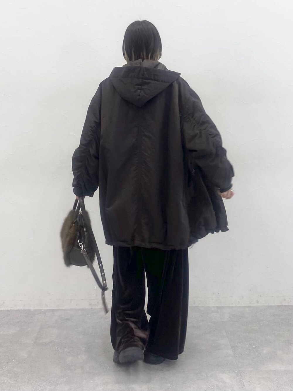 ブラック系のブーツ、ホワイト系のニット/セーター、ブラウン系のブルゾンを着用したレディースの秋コーディネートの6枚目の写真