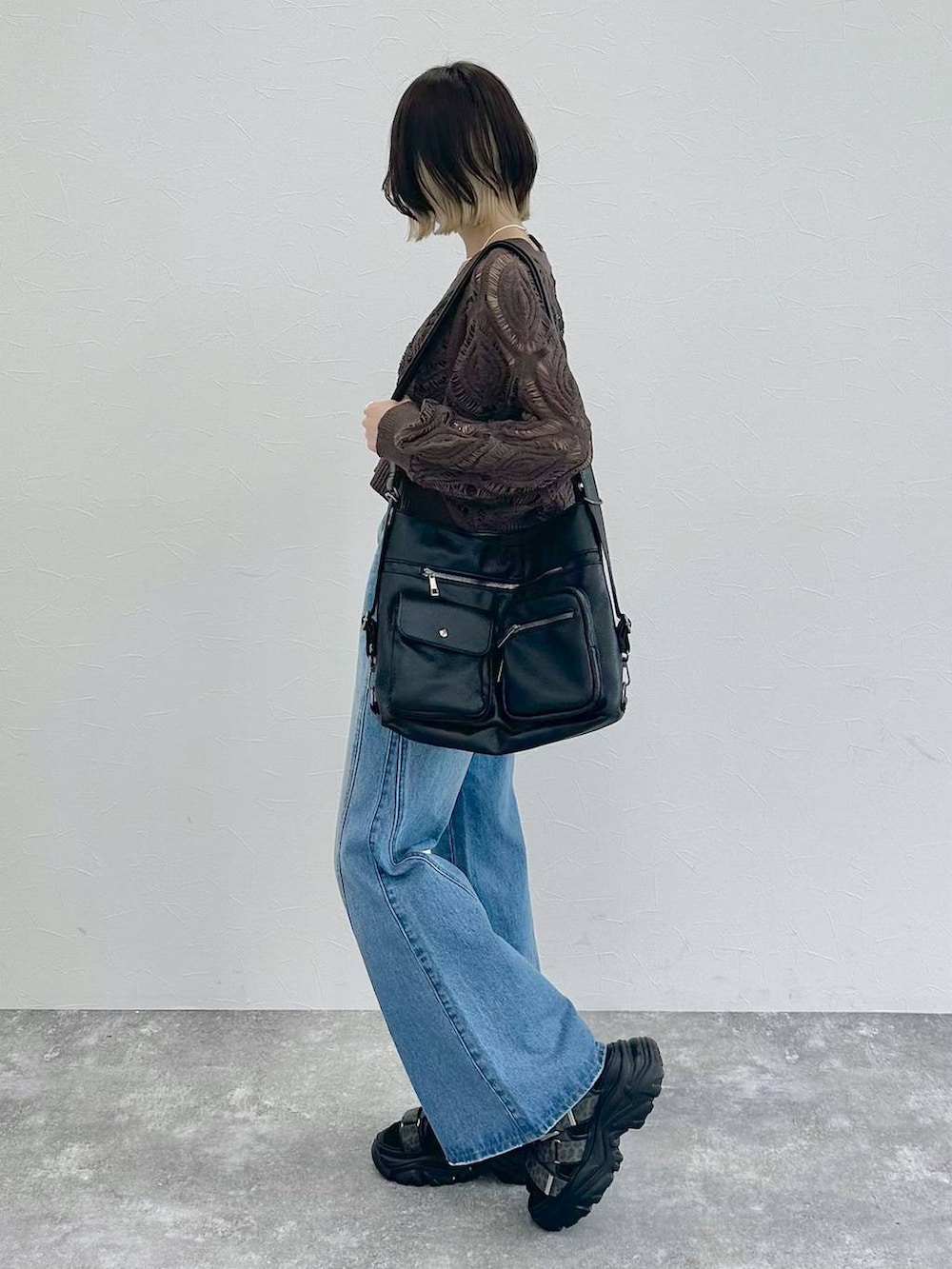 ブラック系のキャミソール、ブラウン系のカーディガン/ボレロ、ブルー系のデニムパンツを着用したレディースの春コーディネートの5枚目の写真