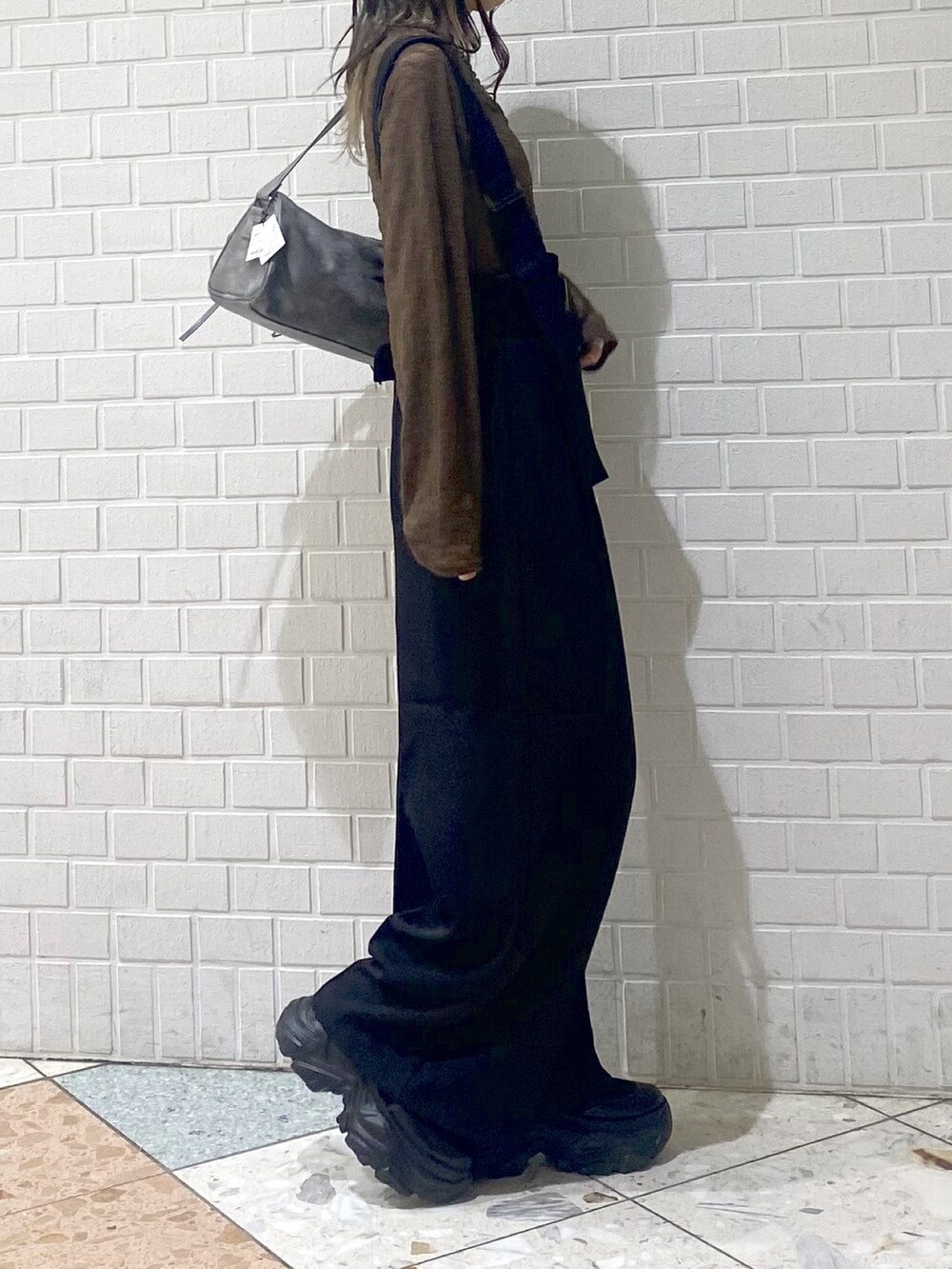 ブラック系のブーツ、ブラック系のスラックス、ブラウン系のTシャツ/カットソーを着用したレディースの秋コーディネートの5枚目の写真