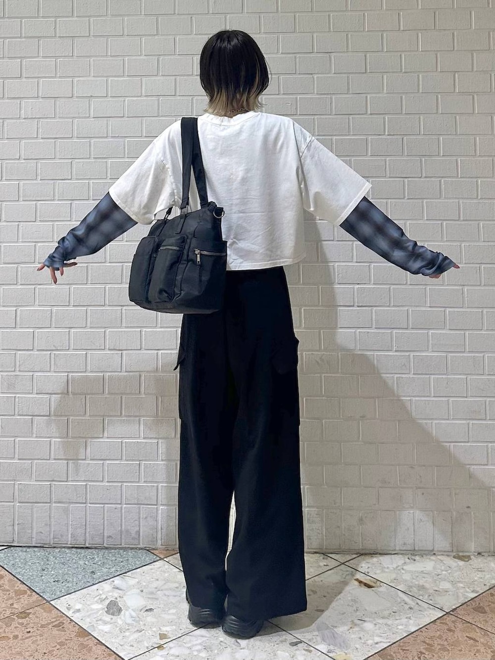 ブラック系のボストンバッグ、ブラック系のサンダル、ホワイト系のTシャツ/カットソーを着用したレディースの春コーディネートの5枚目の写真