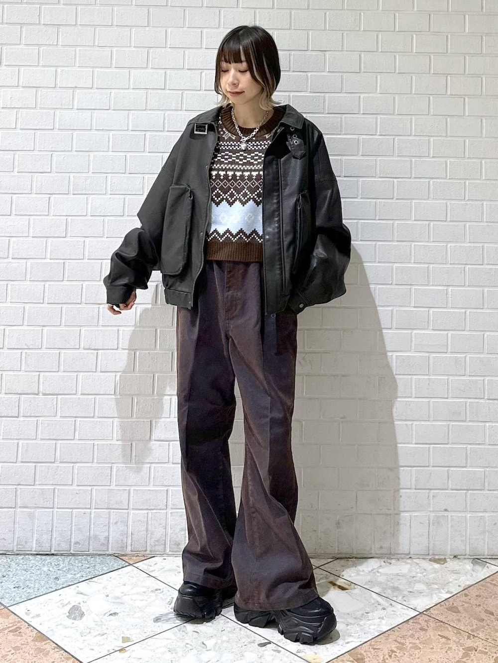 ブラック系のブーツ、ブラック系のブルゾン、ブルー系のデニムパンツを着用したレディースの冬コーディネートの3枚目の写真