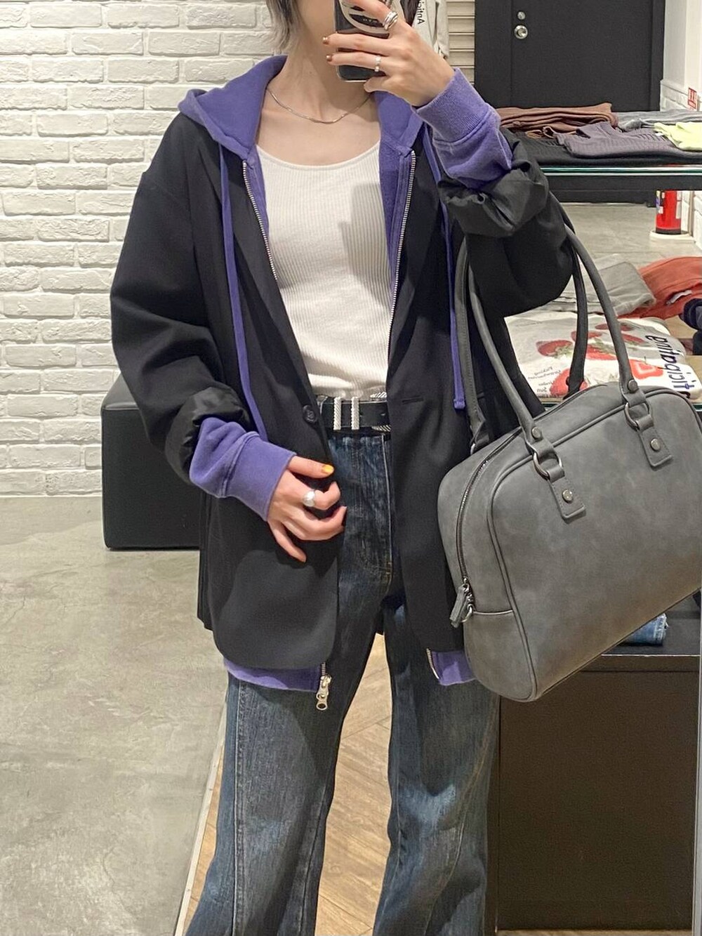 グレー系のボストンバッグ、ブルー系のデニムパンツ、ブラック系のテーラードジャケットを着用したレディースの秋コーディネートの4枚目の写真