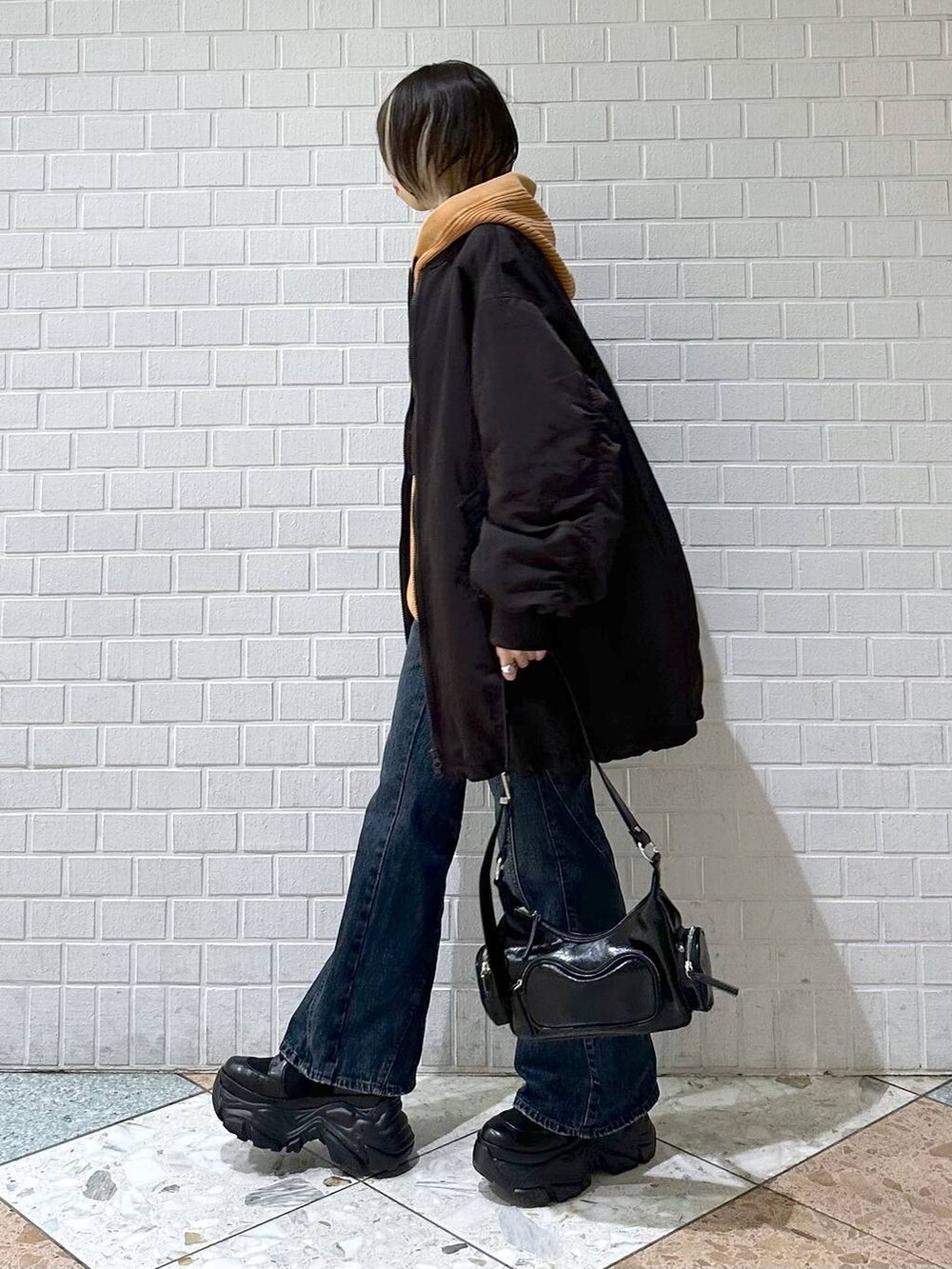 ブラック系のブーツ、ブルー系のデニムパンツ、ブラウン系のブルゾンを着用したレディースの秋コーディネートの5枚目の写真