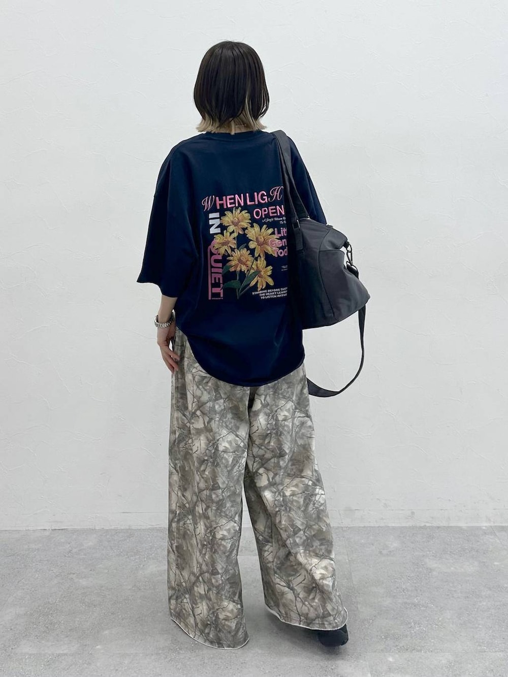グレー系のボストンバッグ、ブラック系のスニーカー、ブルー系のTシャツ/カットソーを着用したレディースの夏コーディネートの5枚目の写真