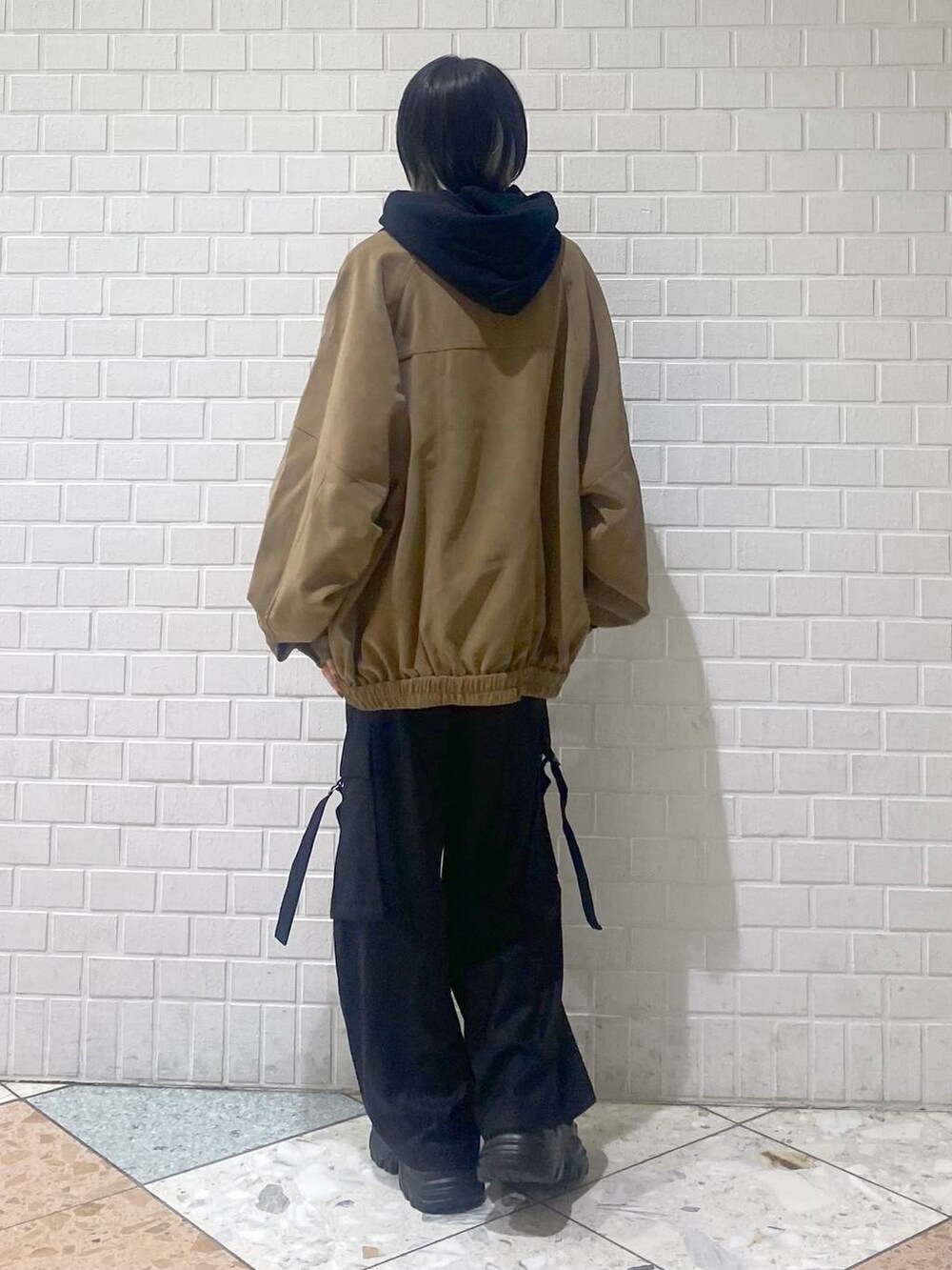 ブラック系のブーツ、ブラック系のパーカー、ベージュ系のブルゾンを着用したレディースの秋コーディネートの8枚目の写真