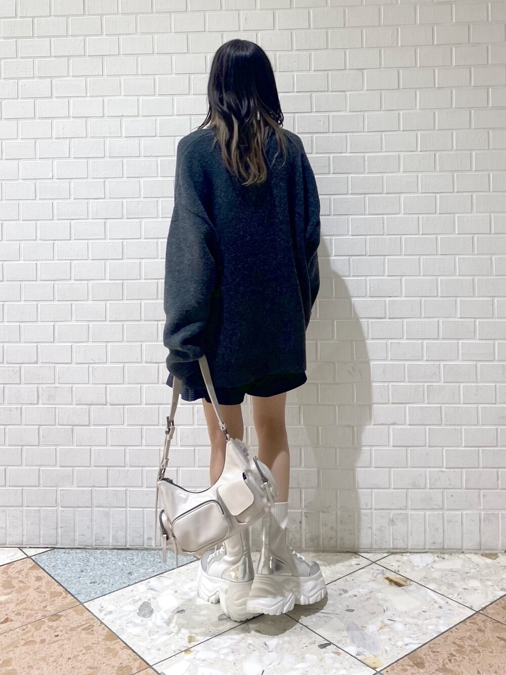 ホワイト系のブーツ、ホワイト系のショルダーバッグ、ブラック系のその他パンツを着用したレディースの秋コーディネートの4枚目の写真