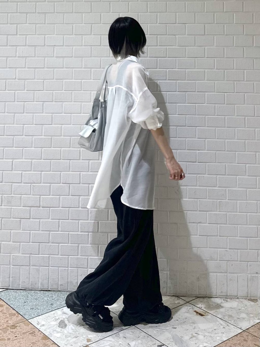 ブラック系のスウェットパンツ、ブラック系のサンダル、ホワイト系のシャツ/ブラウスを着用したレディースの春コーディネートの6枚目の写真