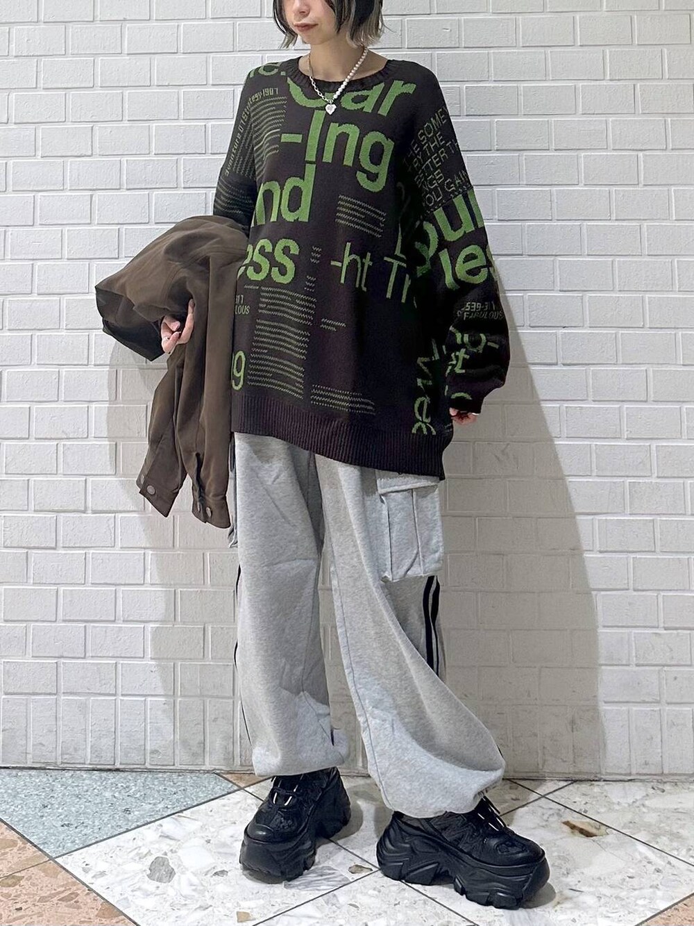 ブラック系のスニーカー、ブラウン系のブルゾン、ブラウン系のニット/セーターを着用したレディースの冬コーディネートの4枚目の写真