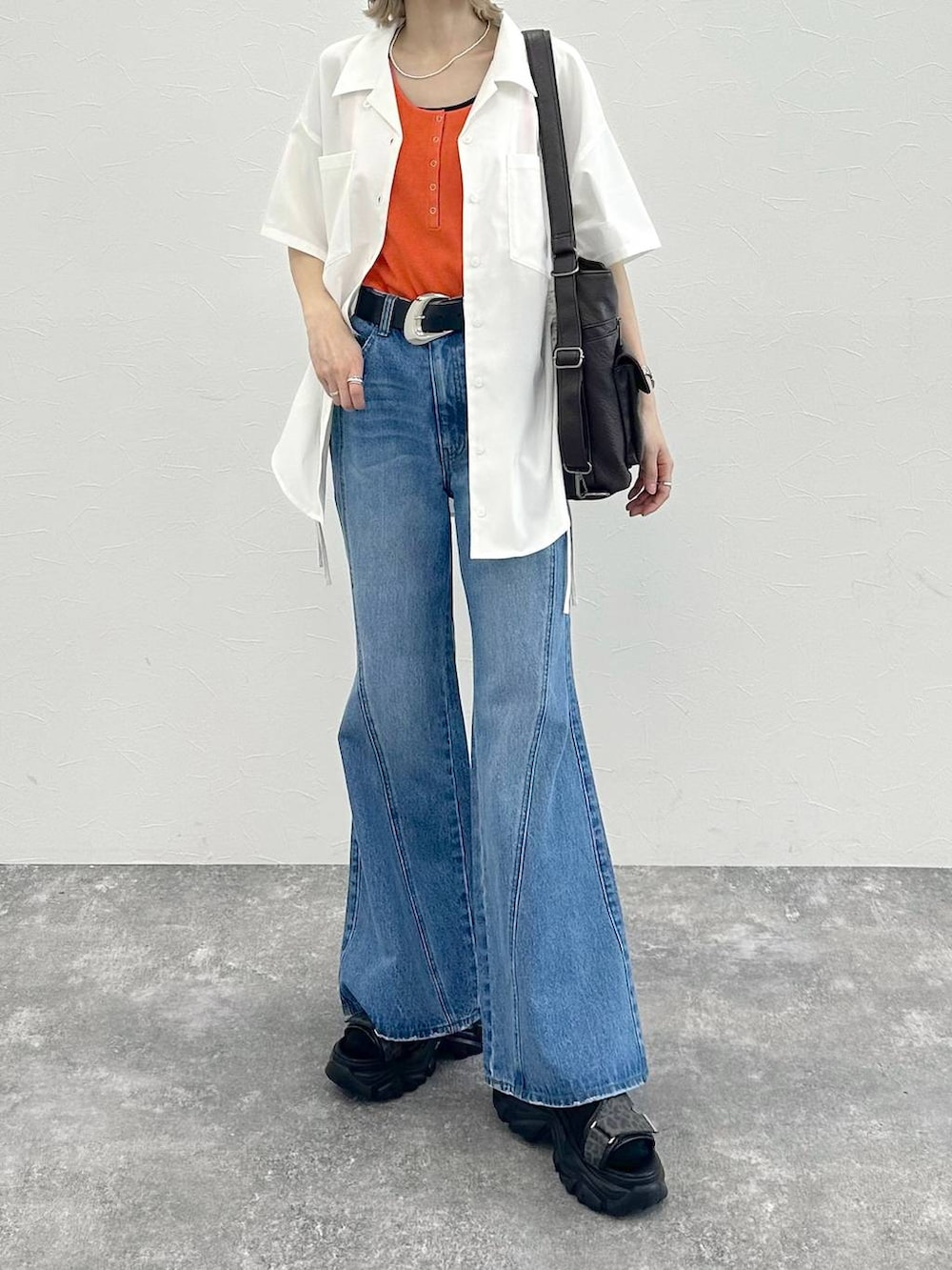 ブルー系のデニムパンツ、ブラック系のショルダーバッグ、グレー系のサンダルを着用したレディースの春コーディネートの3枚目の写真