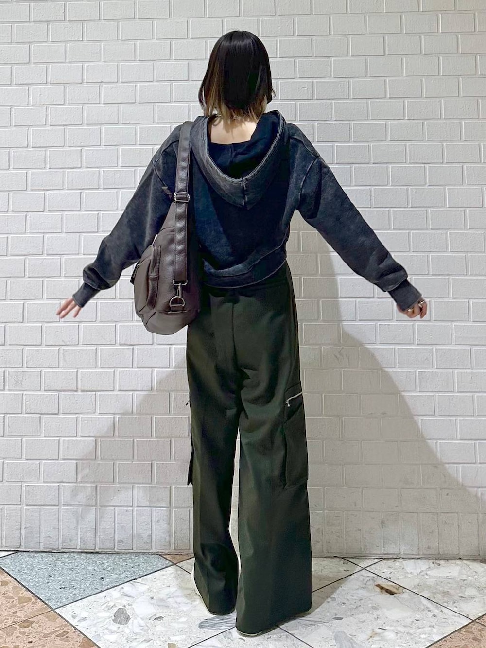 ブラック系のキャミソール、グレー系のパーカー、ホワイト系のスニーカーを着用したレディースの冬コーディネートの6枚目の写真