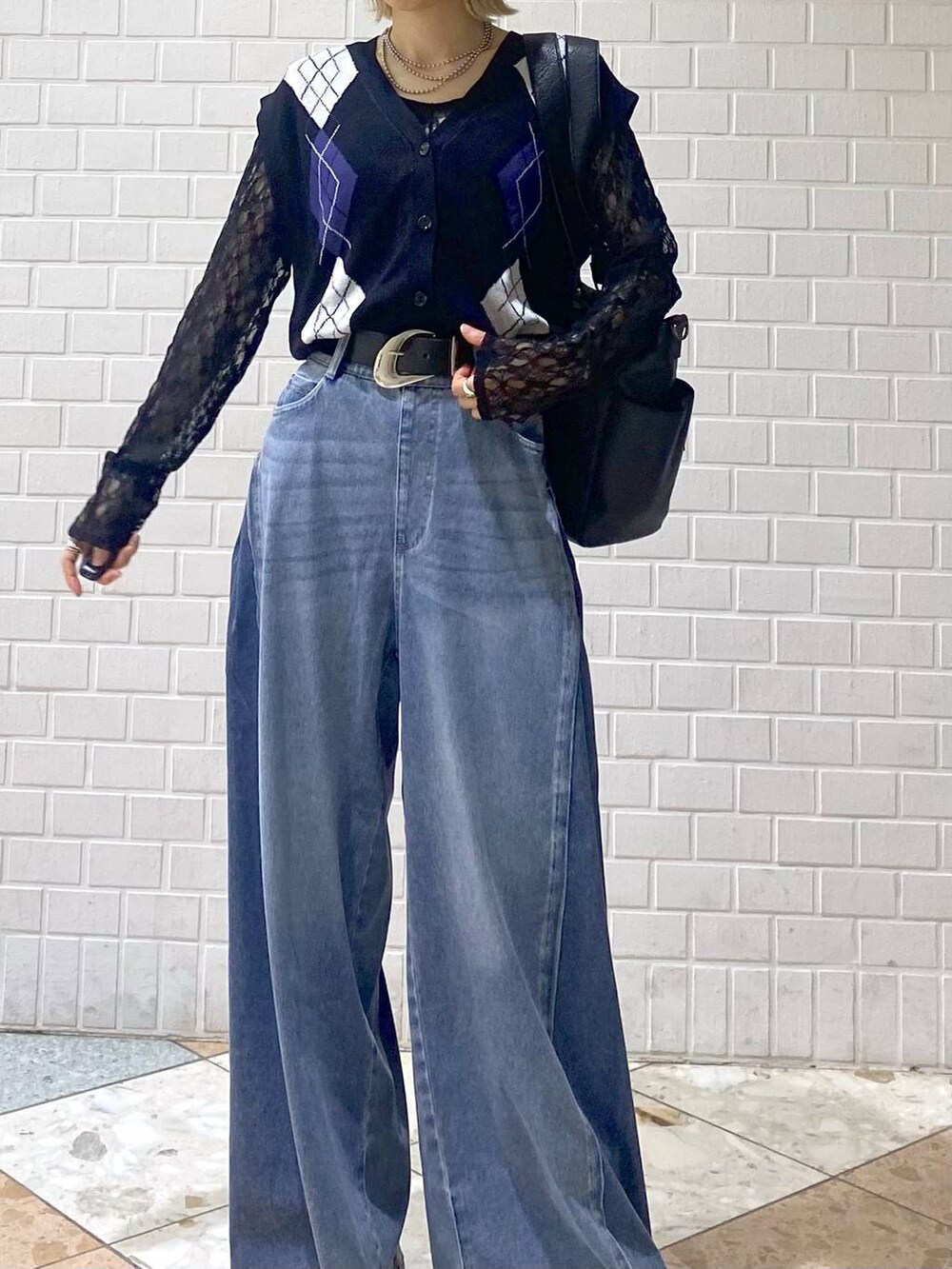 ブラウン系のブーツ、ブルー系のデニムパンツ、ブラック系のボストンバッグを着用したレディースの夏コーディネートの2枚目の写真