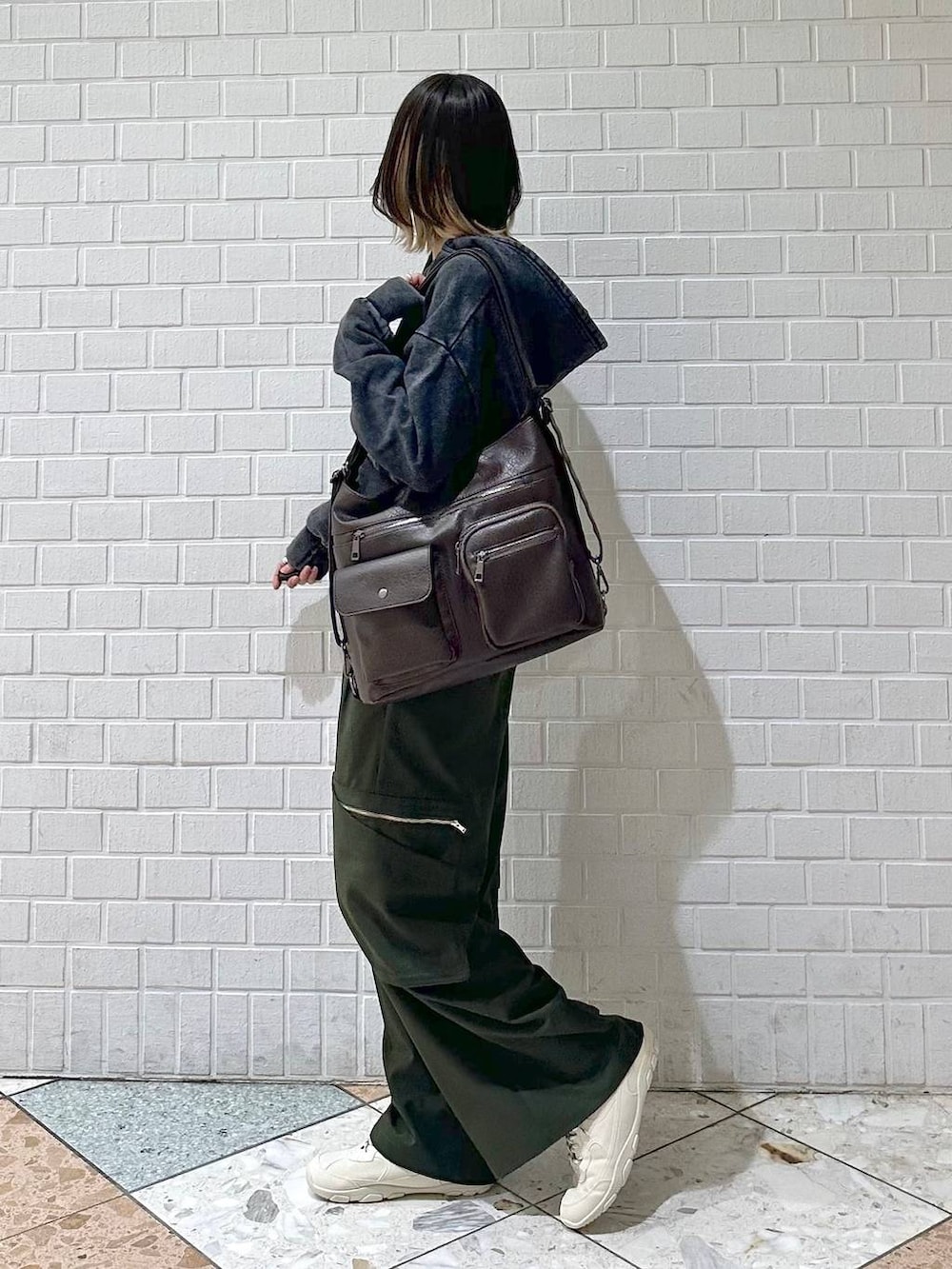 ブラック系のキャミソール、グレー系のパーカー、ホワイト系のスニーカーを着用したレディースの冬コーディネートの5枚目の写真