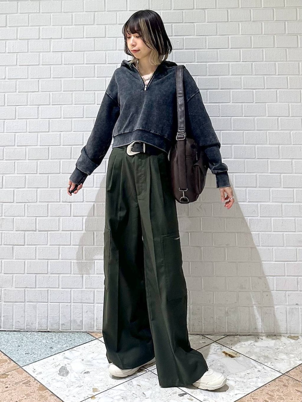 ブラック系のキャミソール、グレー系のパーカー、ホワイト系のスニーカーを着用したレディースの冬コーディネートの4枚目の写真