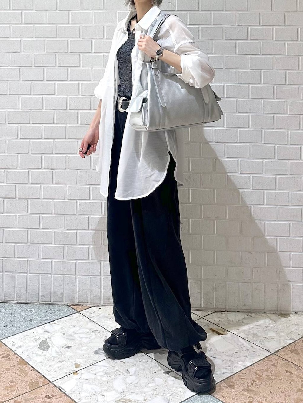 ブラック系のスウェットパンツ、ブラック系のサンダル、ホワイト系のシャツ/ブラウスを着用したレディースの春コーディネートの7枚目の写真