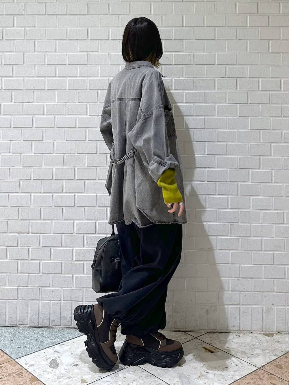 ブラウン系のブーツ、ブラック系のボストンバッグ、ブラック系のシャツ/ブラウスを着用したレディースの冬コーディネートの7枚目の写真