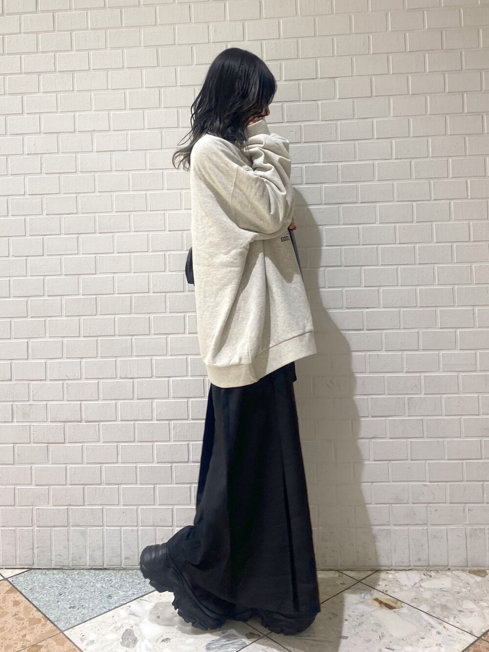 ブラック系のスニーカー、ブラック系のスカート、ベージュ系のスウェットを着用したレディースの冬コーディネートの4枚目の写真