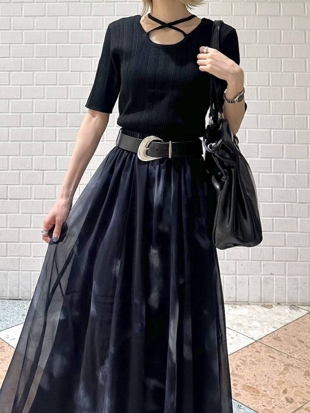 ブラック系のスカート、ブラック系のブーツ、ブラック系のニット/セーターを着用したレディースの夏コーディネートの8枚目の写真