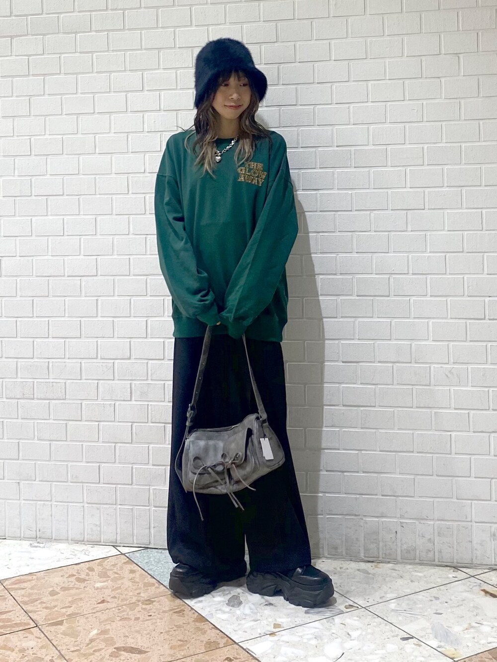 ブラック系のブーツ、ブラック系のスラックス、グレー系のショルダーバッグを着用したレディースの秋コーディネートの2枚目の写真