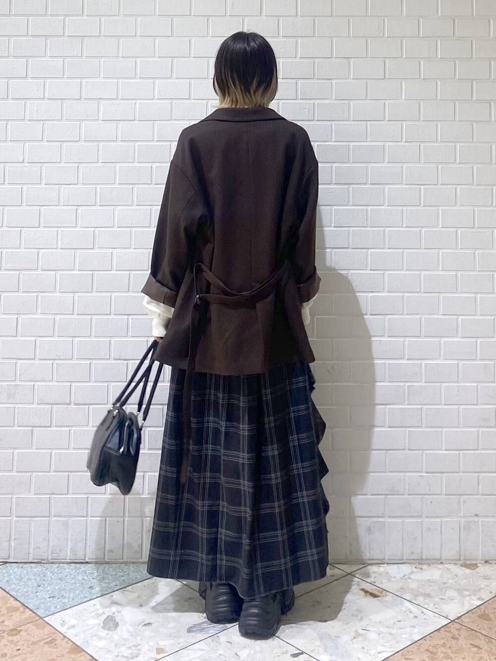 ブラウン系のブーツ、ブラック系のボストンバッグ、ホワイト系のニット/セーターを着用したレディースの秋コーディネートの5枚目の写真