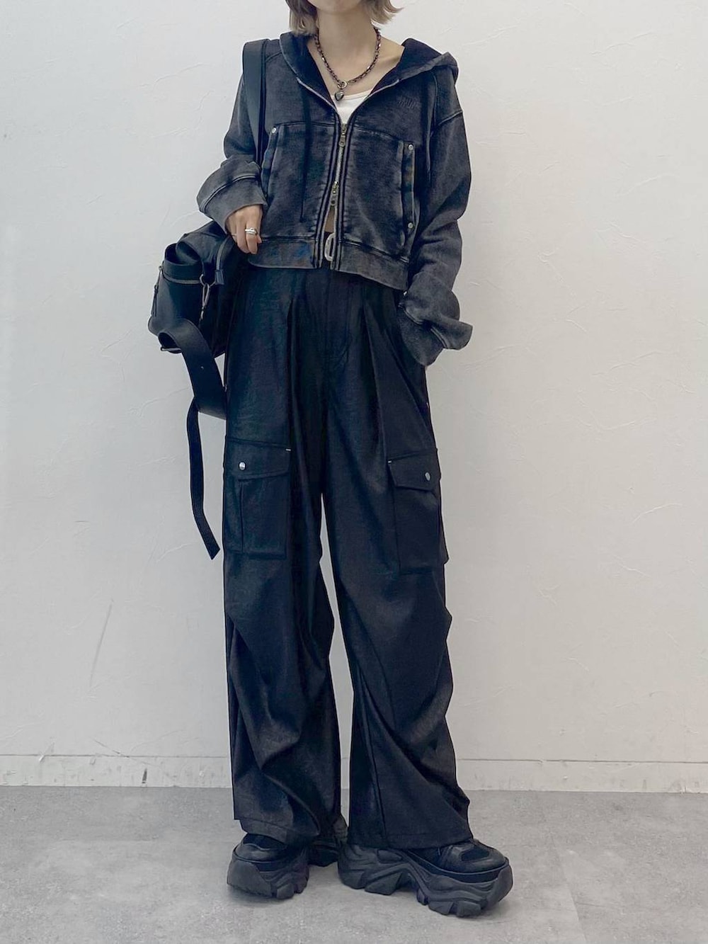 ブラック系のスニーカー、ホワイト系のキャミソール、ブラック系のカーゴパンツを着用したレディースの夏コーディネートの2枚目の写真