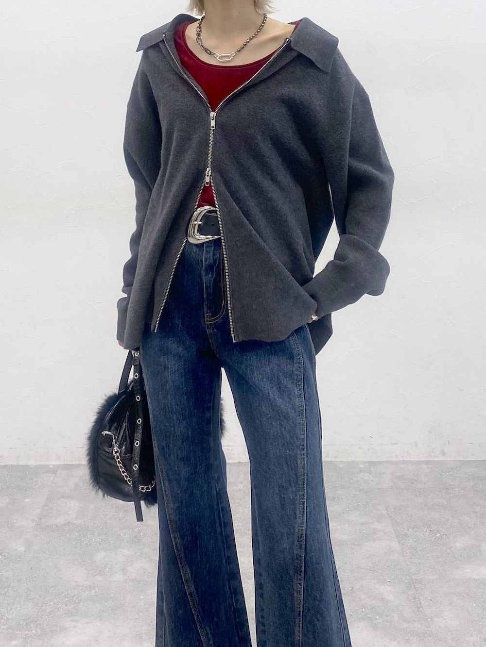 ブラック系のブーツ、ブルー系のデニムパンツ、レッド系のTシャツ/カットソーを着用したレディースの秋コーディネートの8枚目の写真