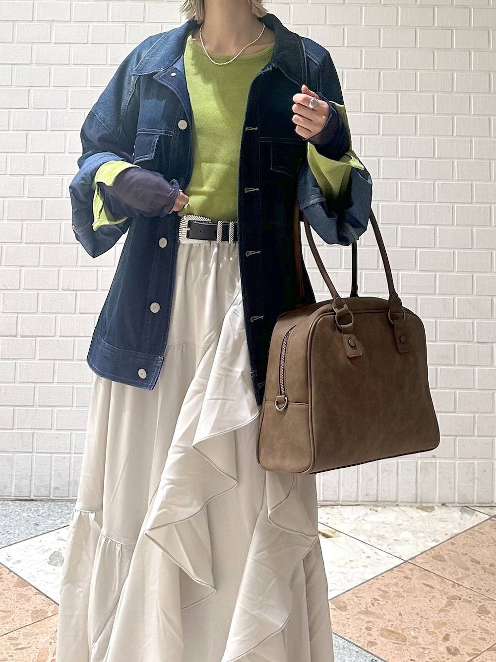 ブラウン系のブーツ、イエロー系のボストンバッグ、ベージュ系のスカートを着用したレディースの冬コーディネートの9枚目の写真