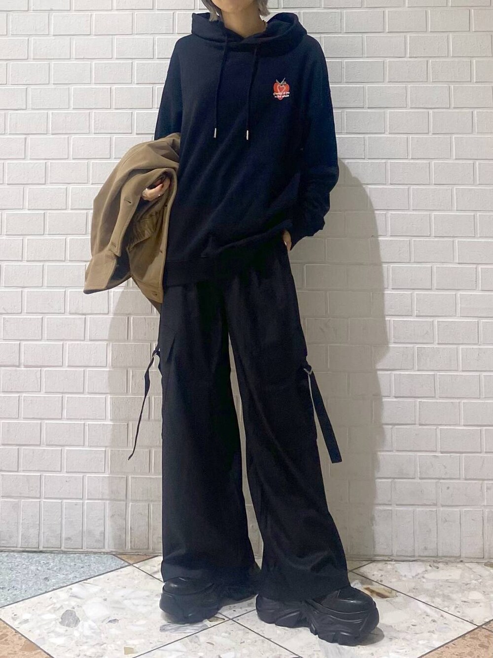 ブラック系のブーツ、ブラック系のパーカー、ベージュ系のブルゾンを着用したレディースの秋コーディネートの4枚目の写真