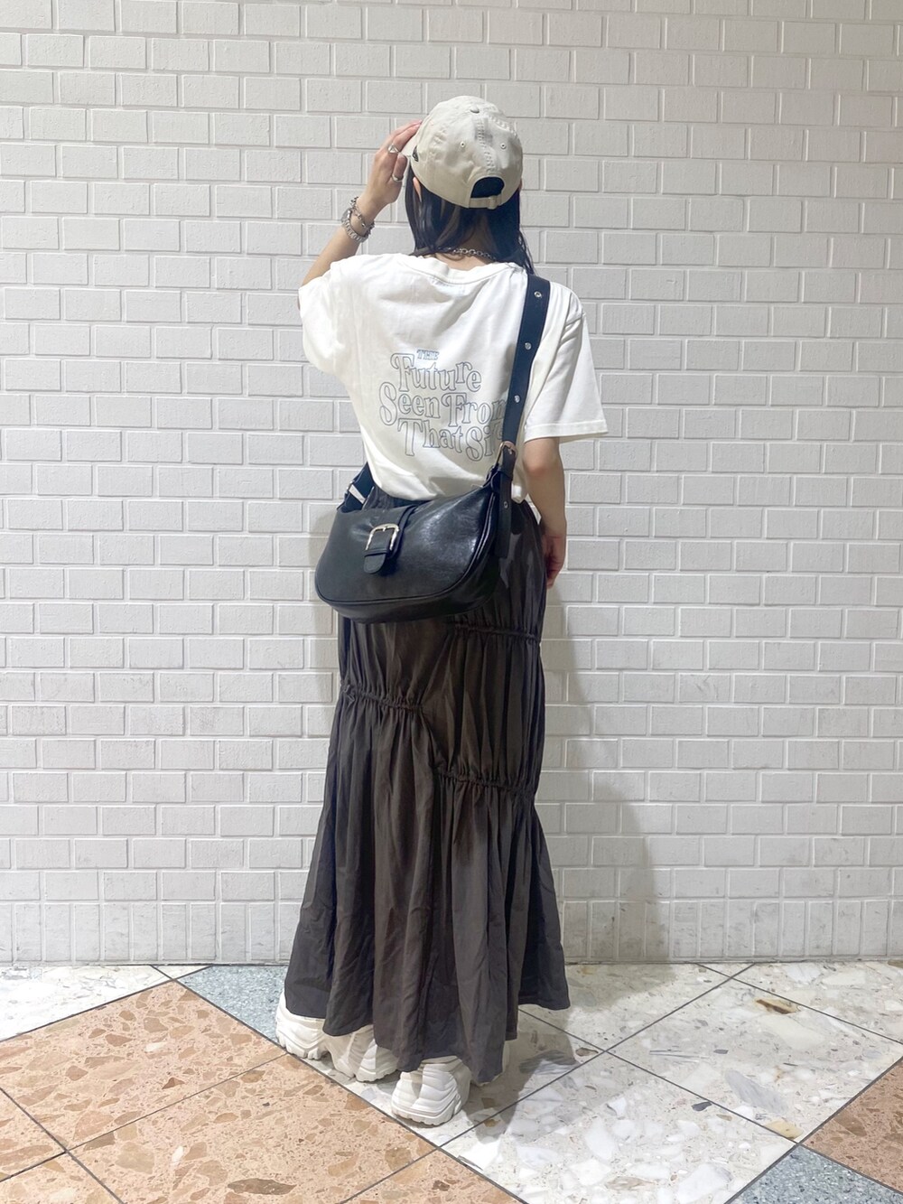 ホワイト系のスニーカー、ブラック系のショルダーバッグ、ベージュ系のTシャツ/カットソーを着用したレディースの夏コーディネートの5枚目の写真