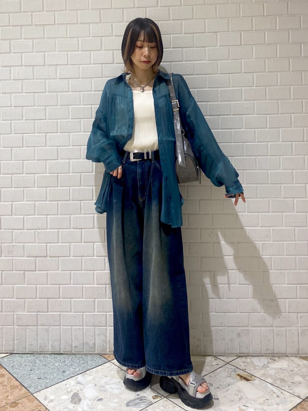 グレー系のサンダル、ブルー系のデニムパンツ、グリーン系のシャツ/ブラウスを着用したレディースの春コーディネートの2枚目の写真