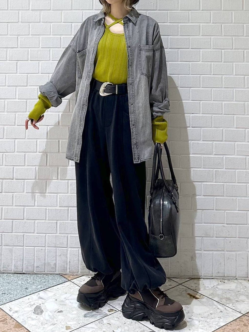 ブラウン系のブーツ、ブラック系のボストンバッグ、ブラック系のシャツ/ブラウスを着用したレディースの冬コーディネートの2枚目の写真