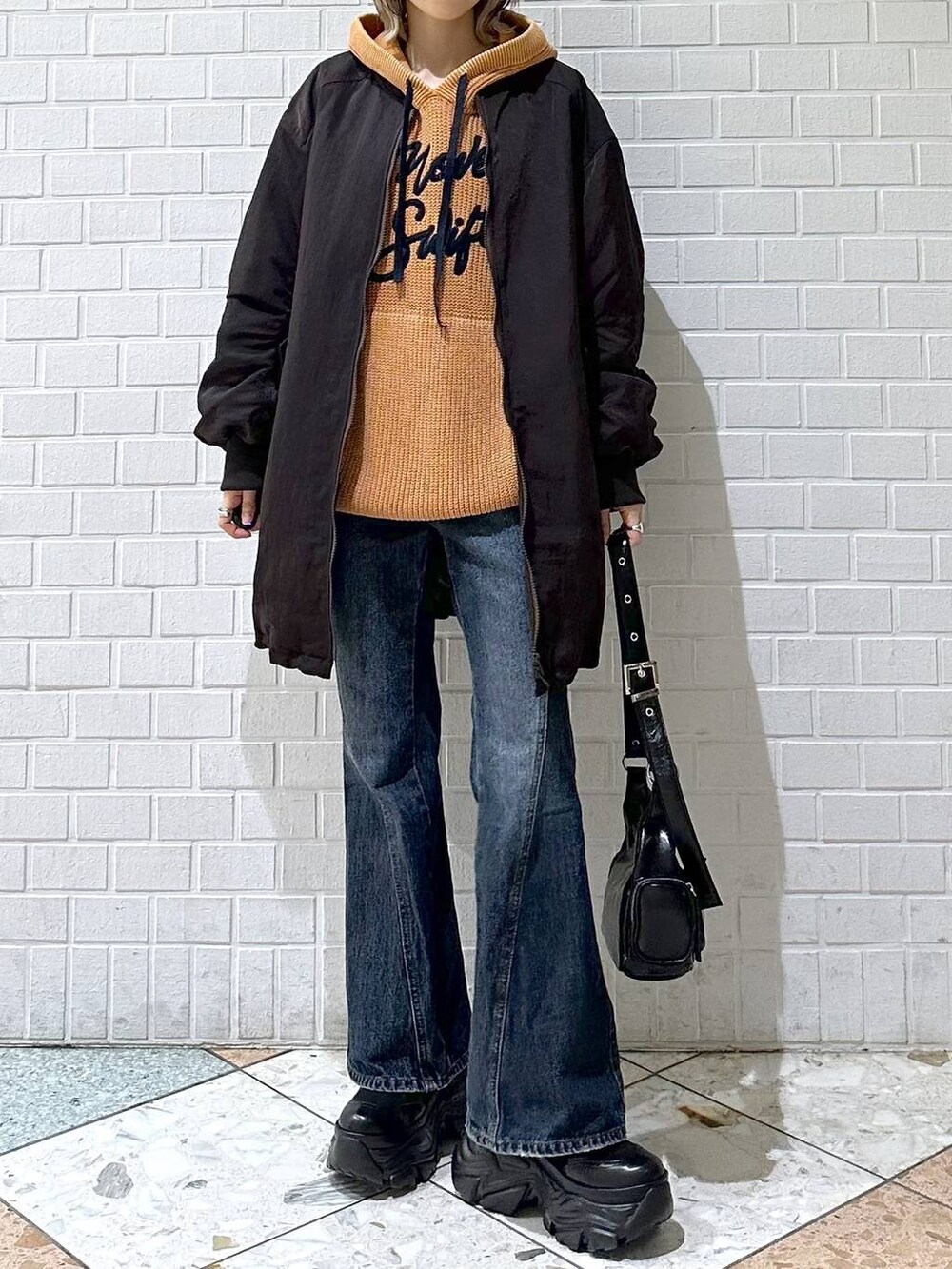 ブラック系のブーツ、ブルー系のデニムパンツ、ブラウン系のブルゾンを着用したレディースの秋コーディネートの9枚目の写真