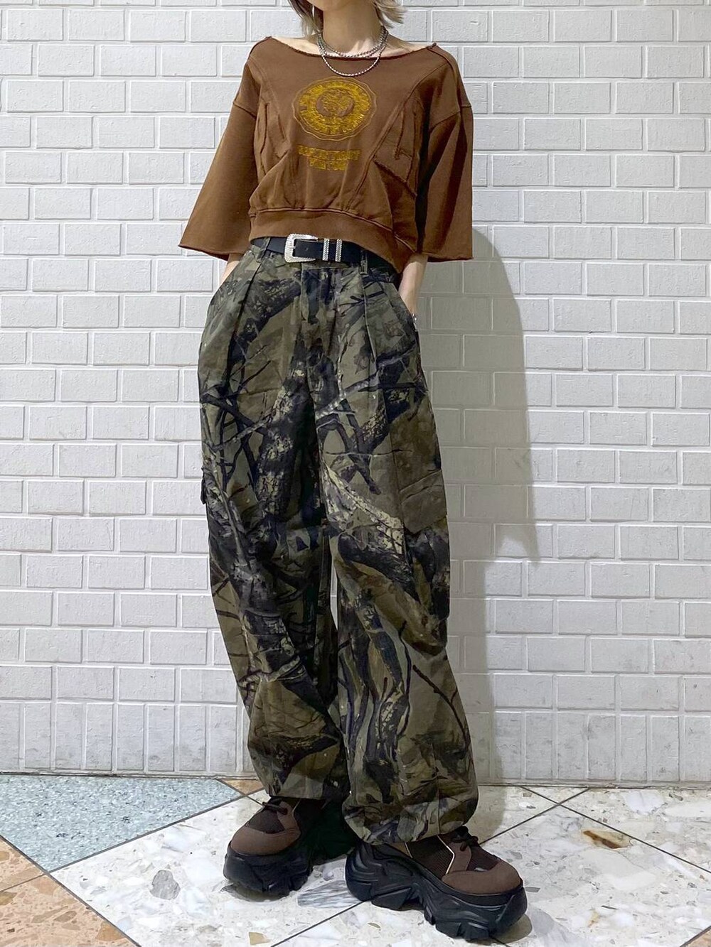 ブラウン系のブーツ、グリーン系のカーゴパンツ、ブラウン系のTシャツ/カットソーを着用したレディースの夏コーディネートの2枚目の写真