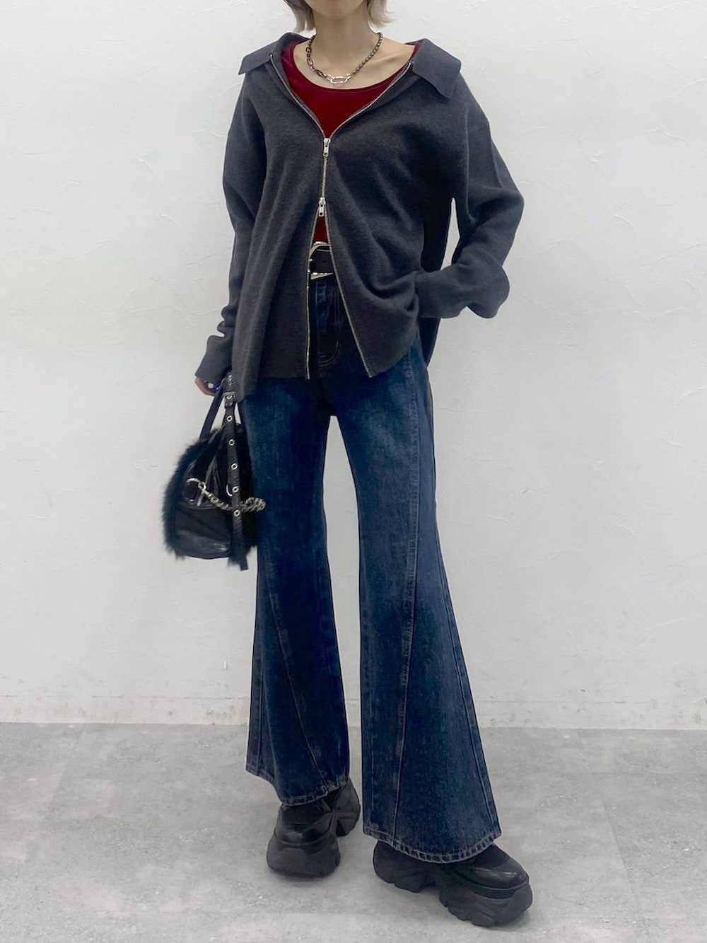 ブラック系のブーツ、ブルー系のデニムパンツ、レッド系のTシャツ/カットソーを着用したレディースの秋コーディネートの2枚目の写真