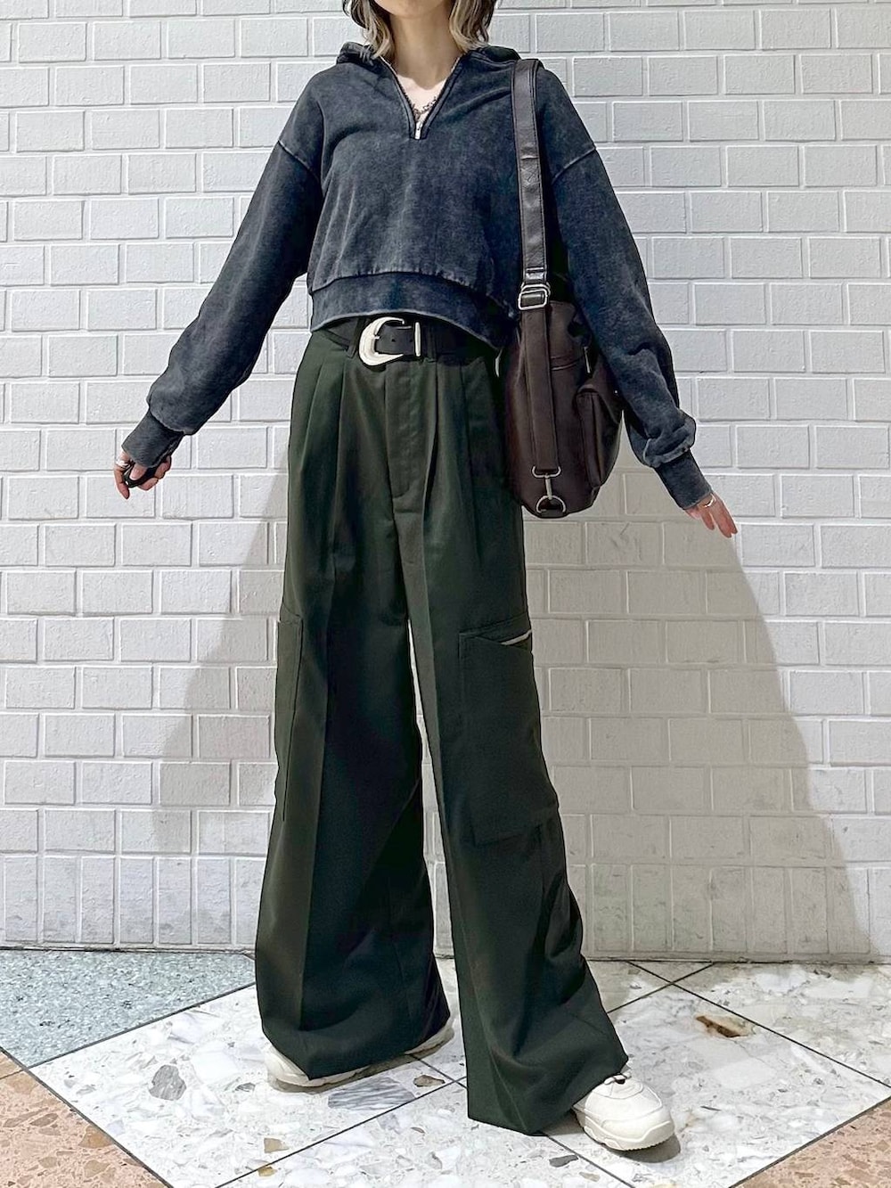 ブラック系のキャミソール、グレー系のパーカー、ホワイト系のスニーカーを着用したレディースの冬コーディネートの2枚目の写真