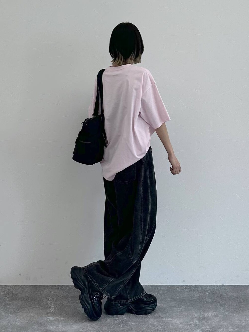 ブラック系のスニーカー、ブラック系のボストンバッグ、ブラック系のデニムパンツを着用したレディースの春コーディネートの8枚目の写真