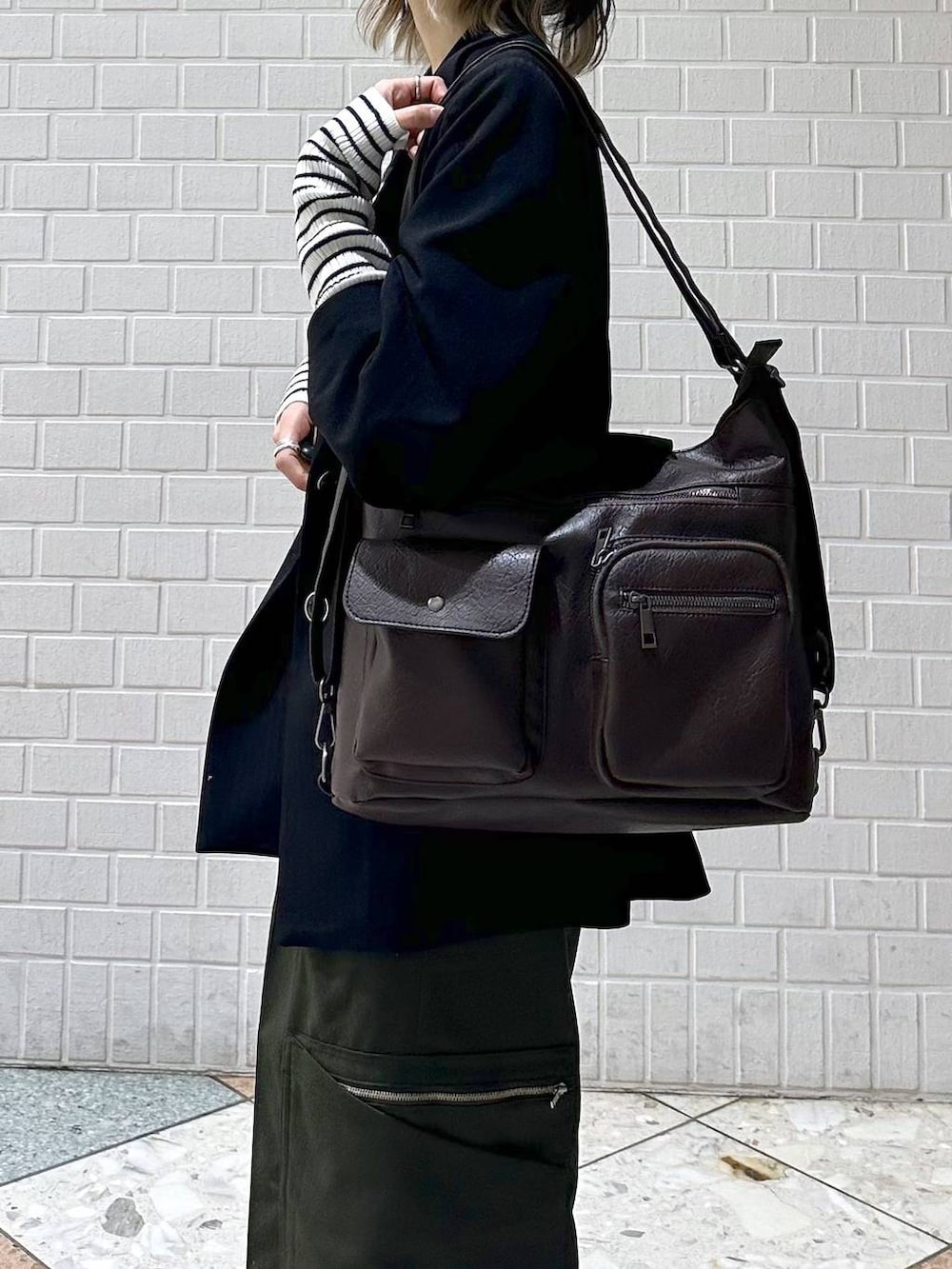 ブラック系のテーラードジャケット、ホワイト系のスニーカー、グリーン系のスラックスを着用したレディースの冬コーディネートの8枚目の写真