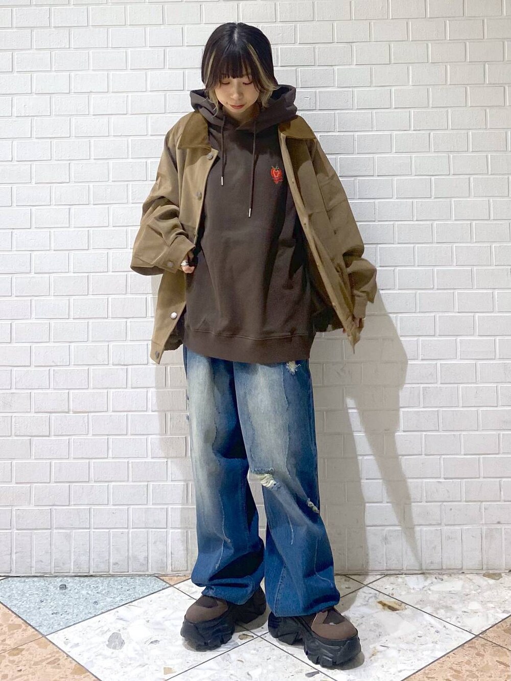 ブラウン系のブーツ、ブルー系のデニムパンツ、ブラウン系のパーカーを着用したレディースの秋コーディネートの4枚目の写真