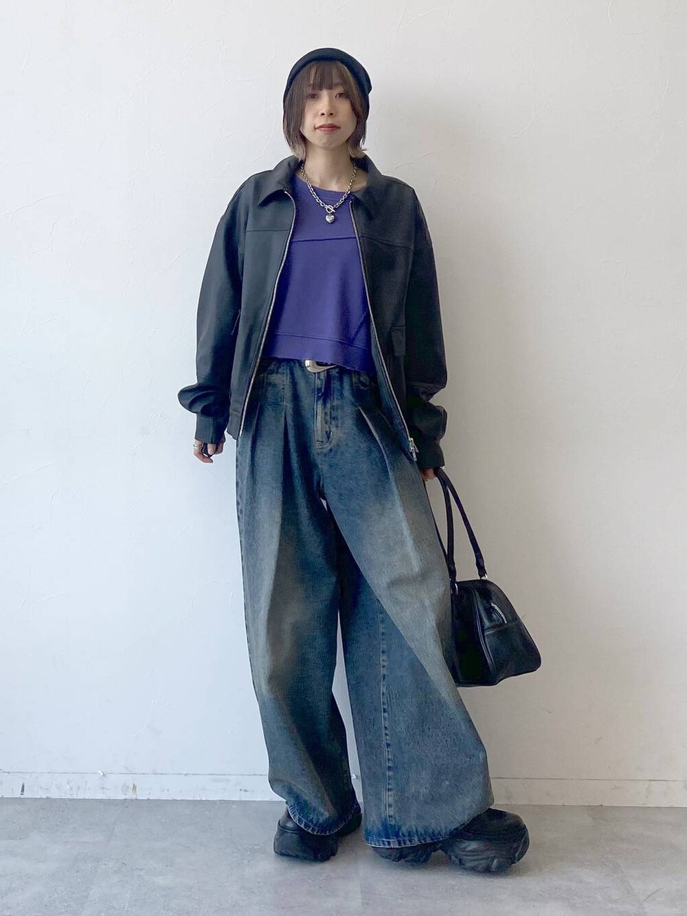 ブラック系のスニーカー、ブルー系のデニムパンツ、ブラック系のブルゾンを着用したレディースの夏コーディネートの3枚目の写真