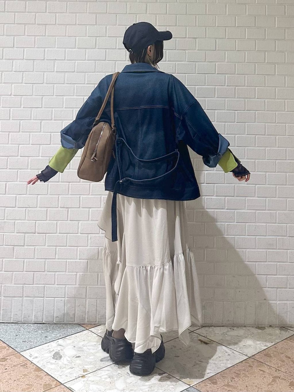 ブラウン系のブーツ、イエロー系のボストンバッグ、ベージュ系のスカートを着用したレディースの冬コーディネートの7枚目の写真