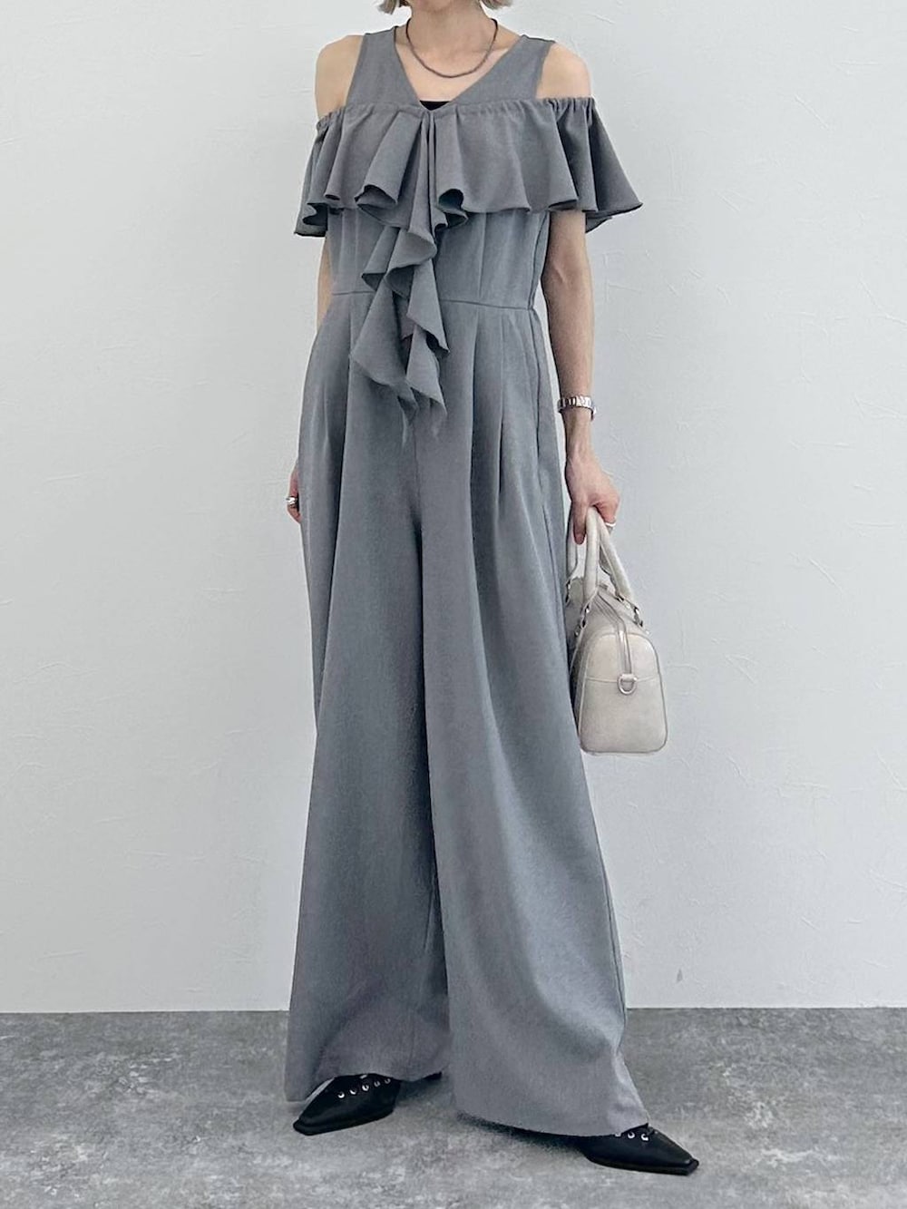 ホワイト系のボストンバッグ、ブラック系のサンダル、グレー系のサロペット/オーバーオールを着用したレディースの春コーディネートの9枚目の写真