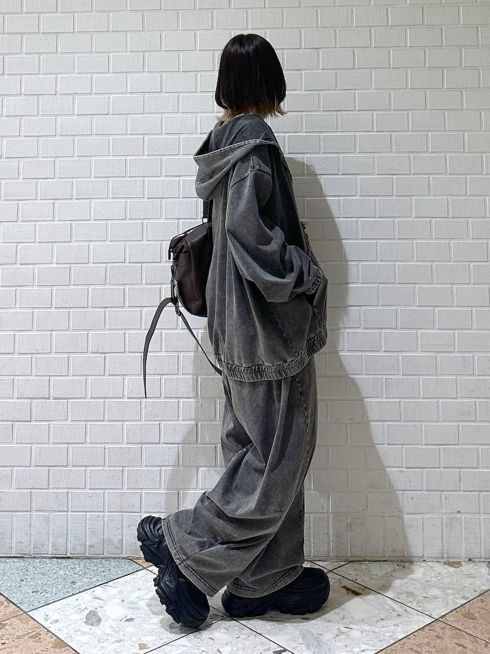 ブラック系のブーツ、ブラック系のキャミソール、ブラウン系のボストンバッグを着用したレディースの冬コーディネートの7枚目の写真